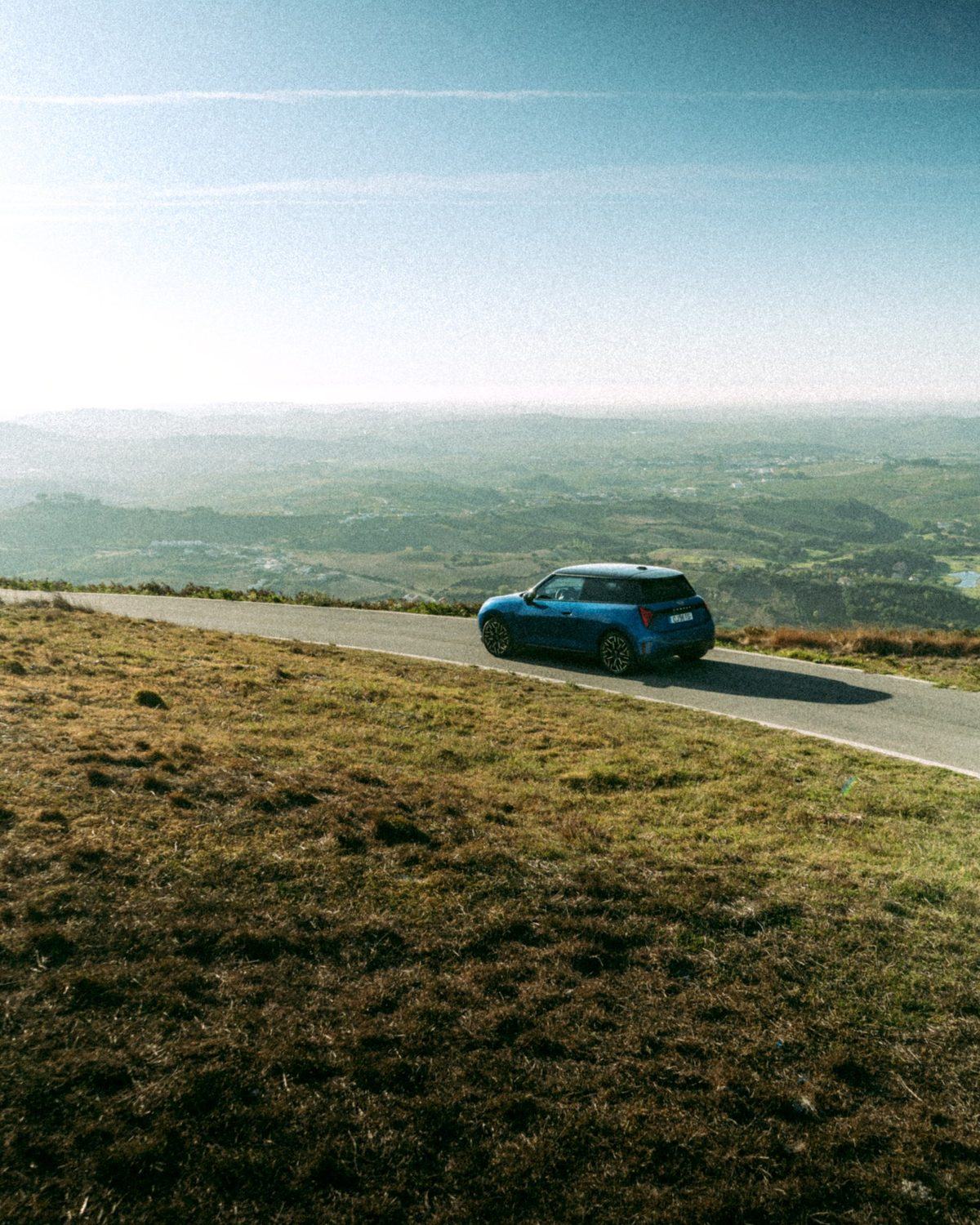Mini Cooper SE azul na estrada do miradouro